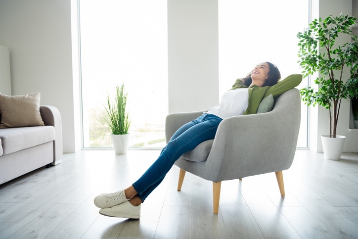 woman relaxing in chair in a clean organized living room