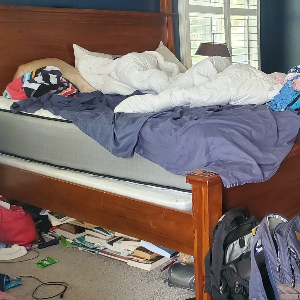 Bedroom with clothes, backpacks and books every where